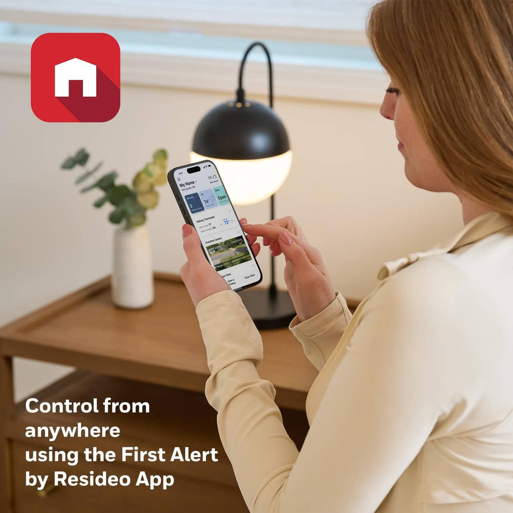 Smart thermostat app control on a smartphone held by a person at home