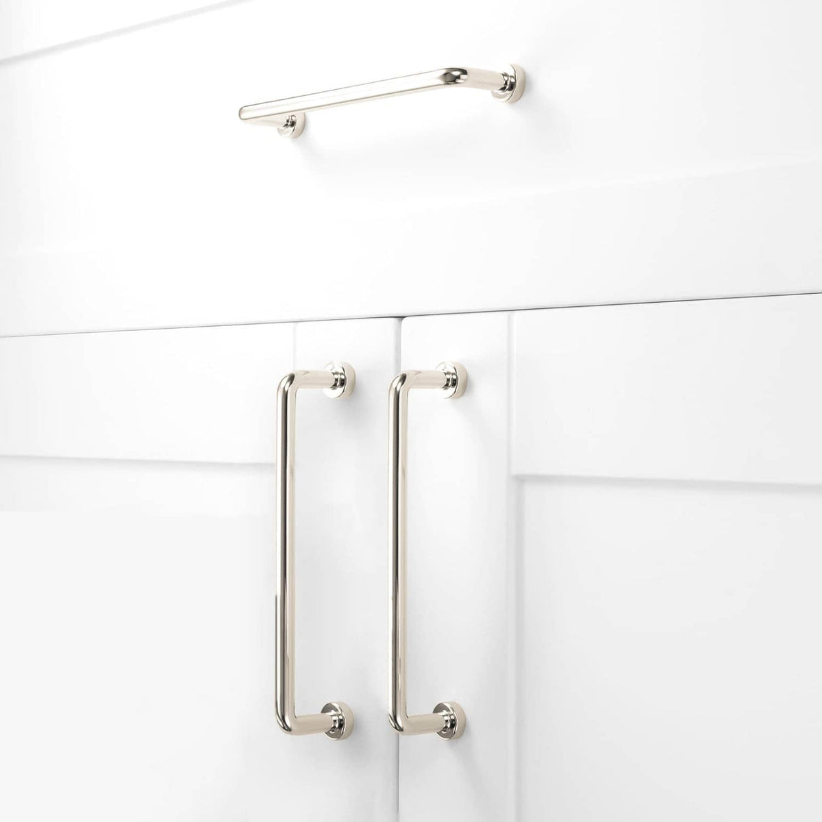 Polished nickel cabinet pull handles mounted on cabinet doors, two-piece set