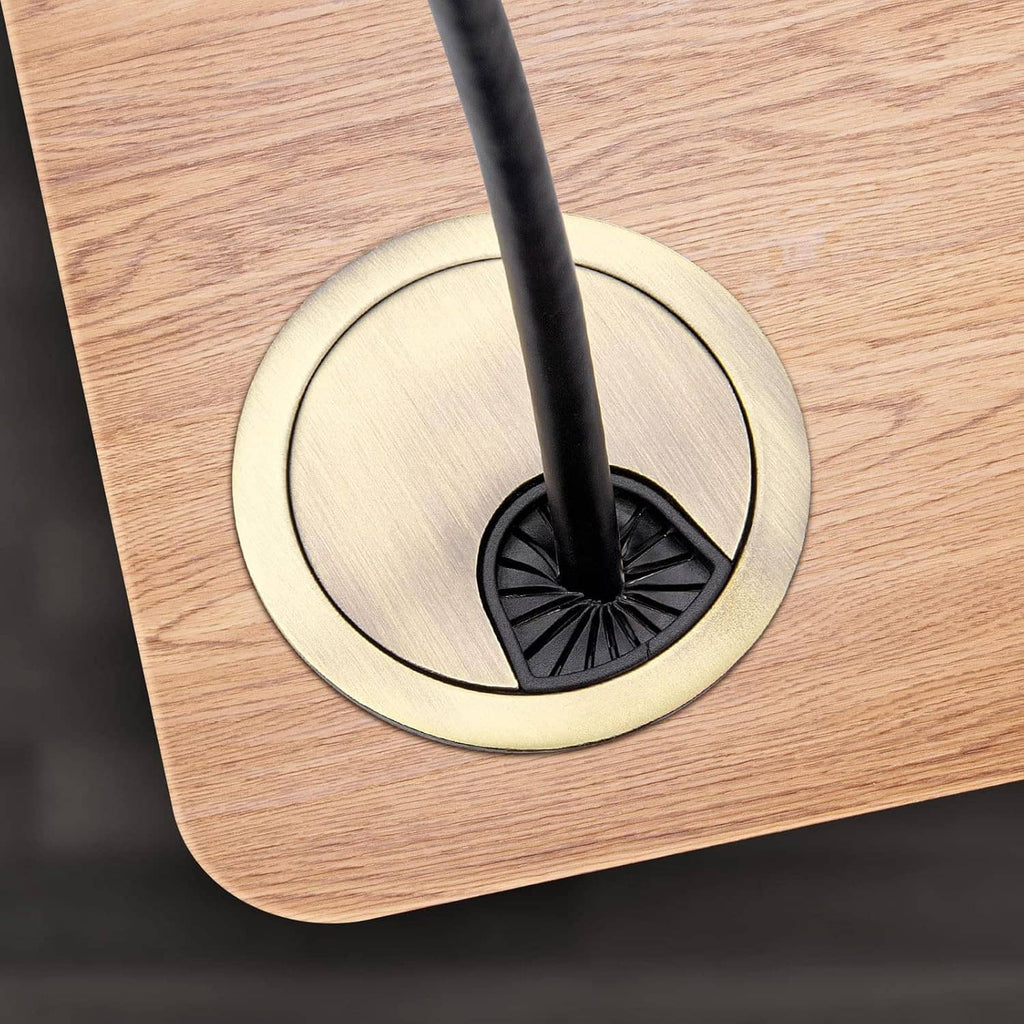 Bronze desk grommet installed in a wood tabletop with a cable passing through