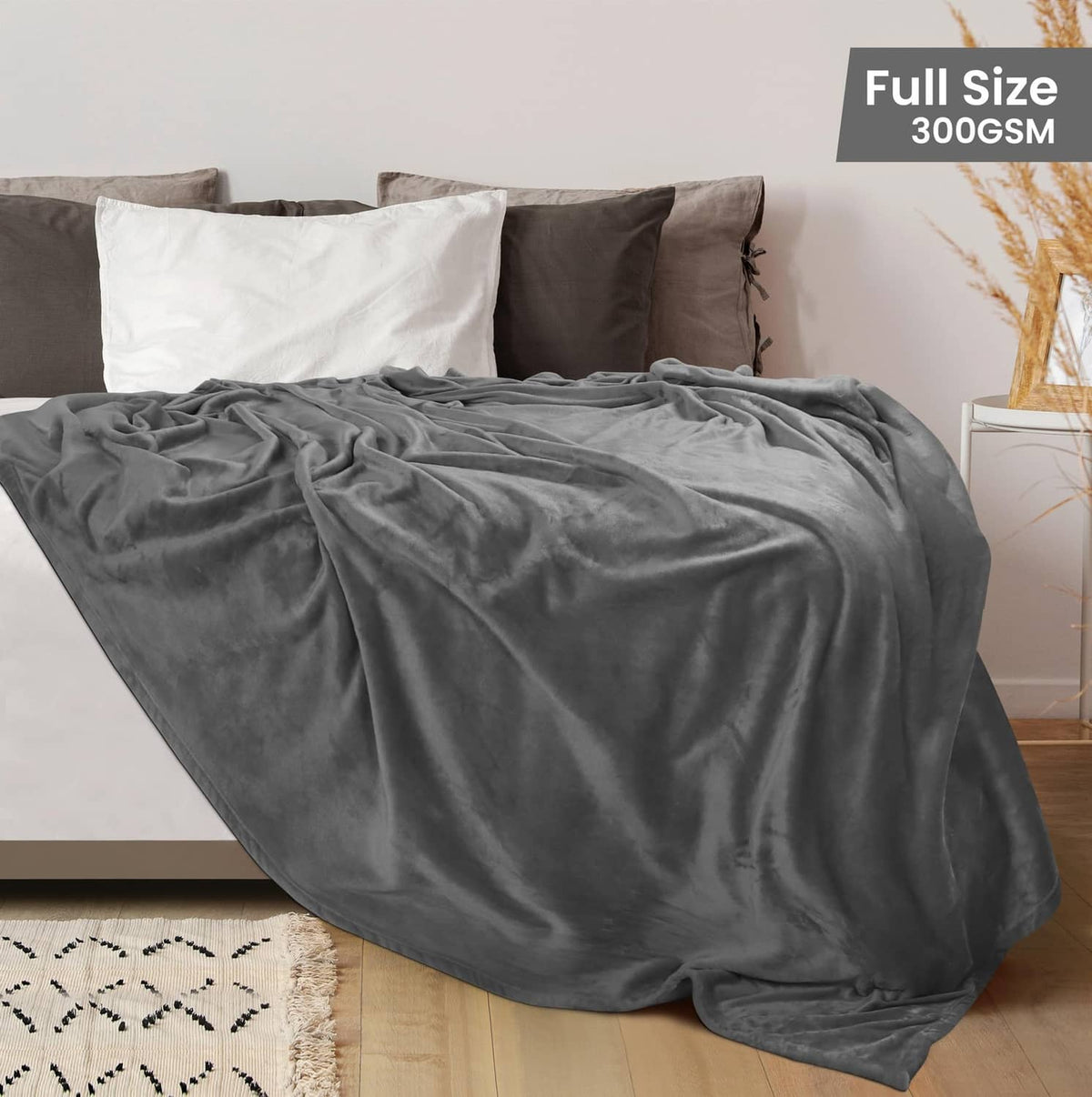 Grey fleece blanket draped across a full-size bed, covering the mattress.