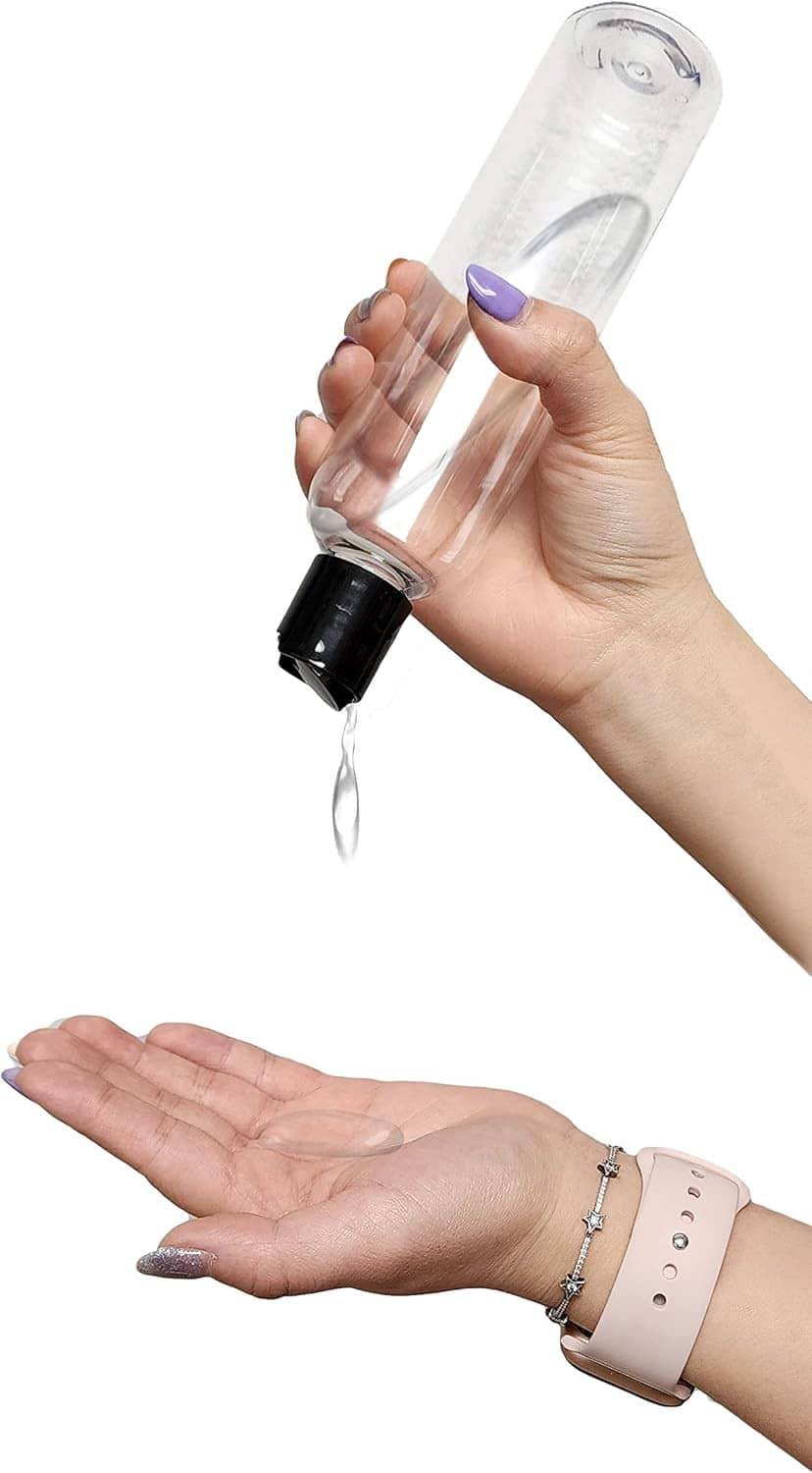 Clear plastic bottle with black disc top cap, shown being filled in hand, refillable container