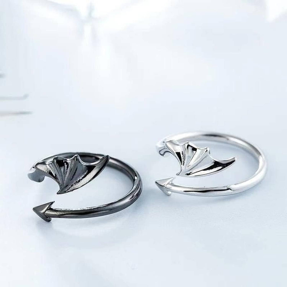Two silver rings with bat-wing motifs on a light background
