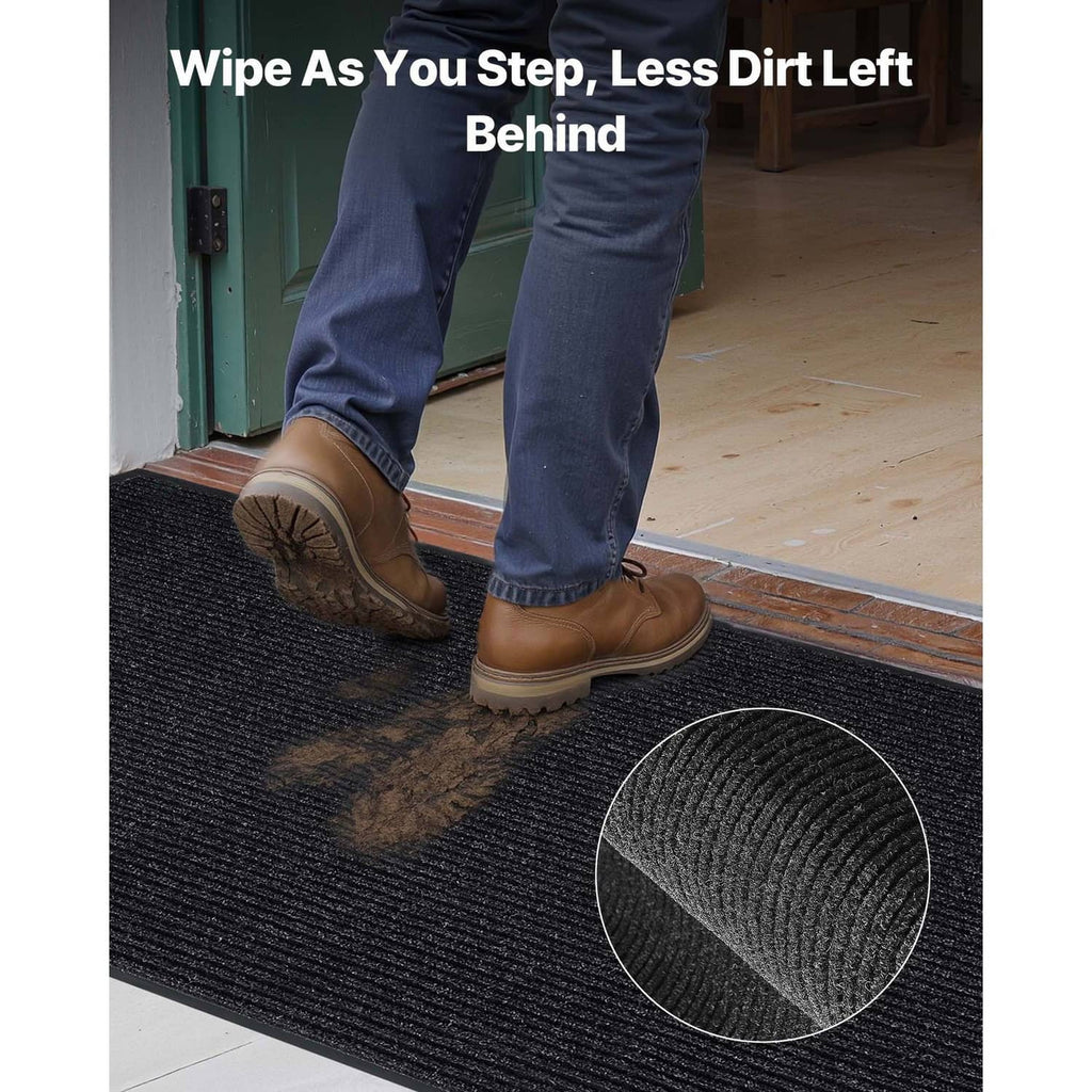 Rectangular black ribbed entrance mat with textured pile to wipe off dirt.