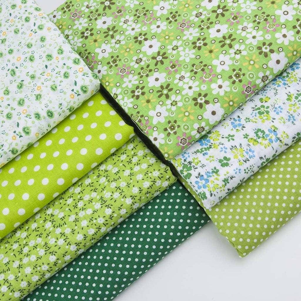 Stack of cotton patchwork fabric squares in green polka dots and floral prints