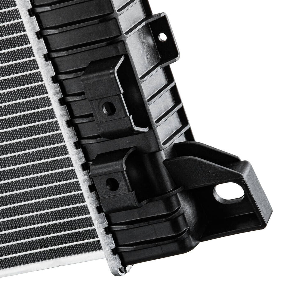 Automotive radiator bracket detail with black plastic mounts beside silver fin core