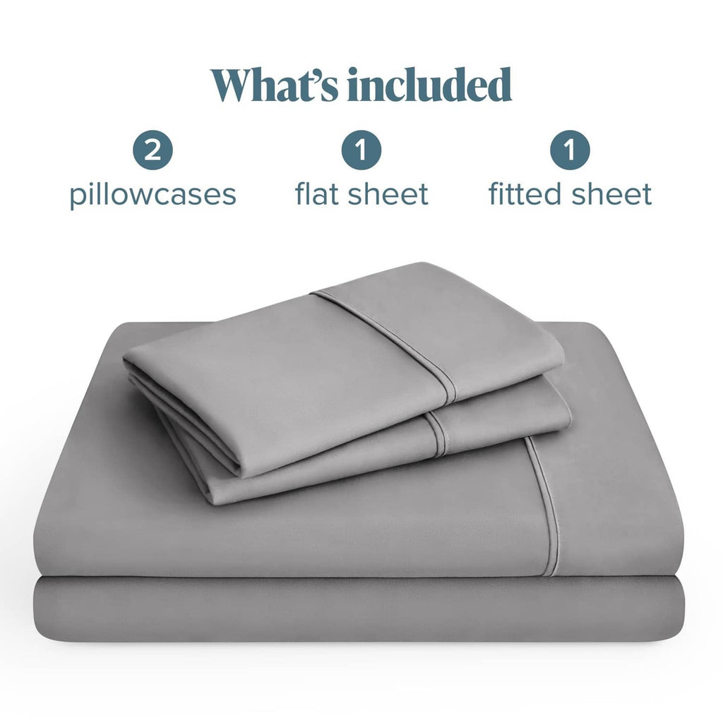 Light grey folded sheet set stack: flat sheet, fitted sheet, plus two pillowcases