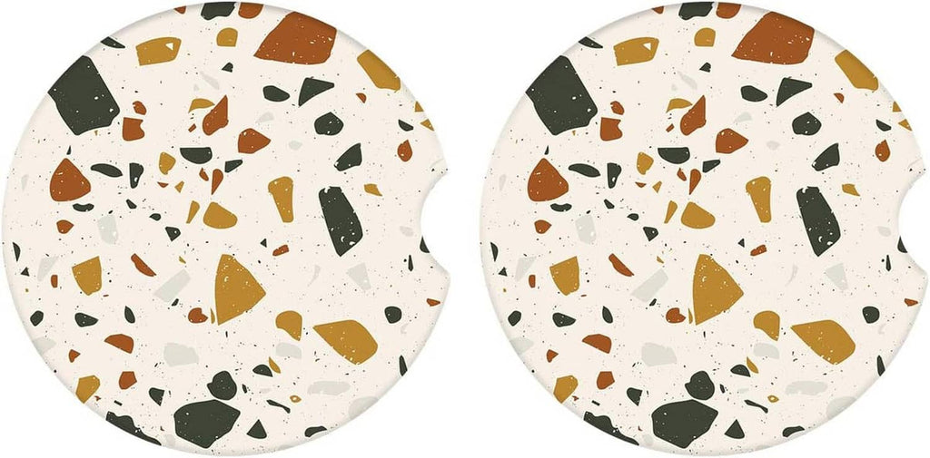 Two round speckled ceramic coasters with brown, green, and white terrazzo pattern