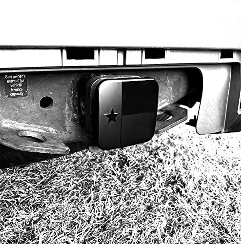 Black square hitch cover plugged into receiver, Texas star emblem centered.