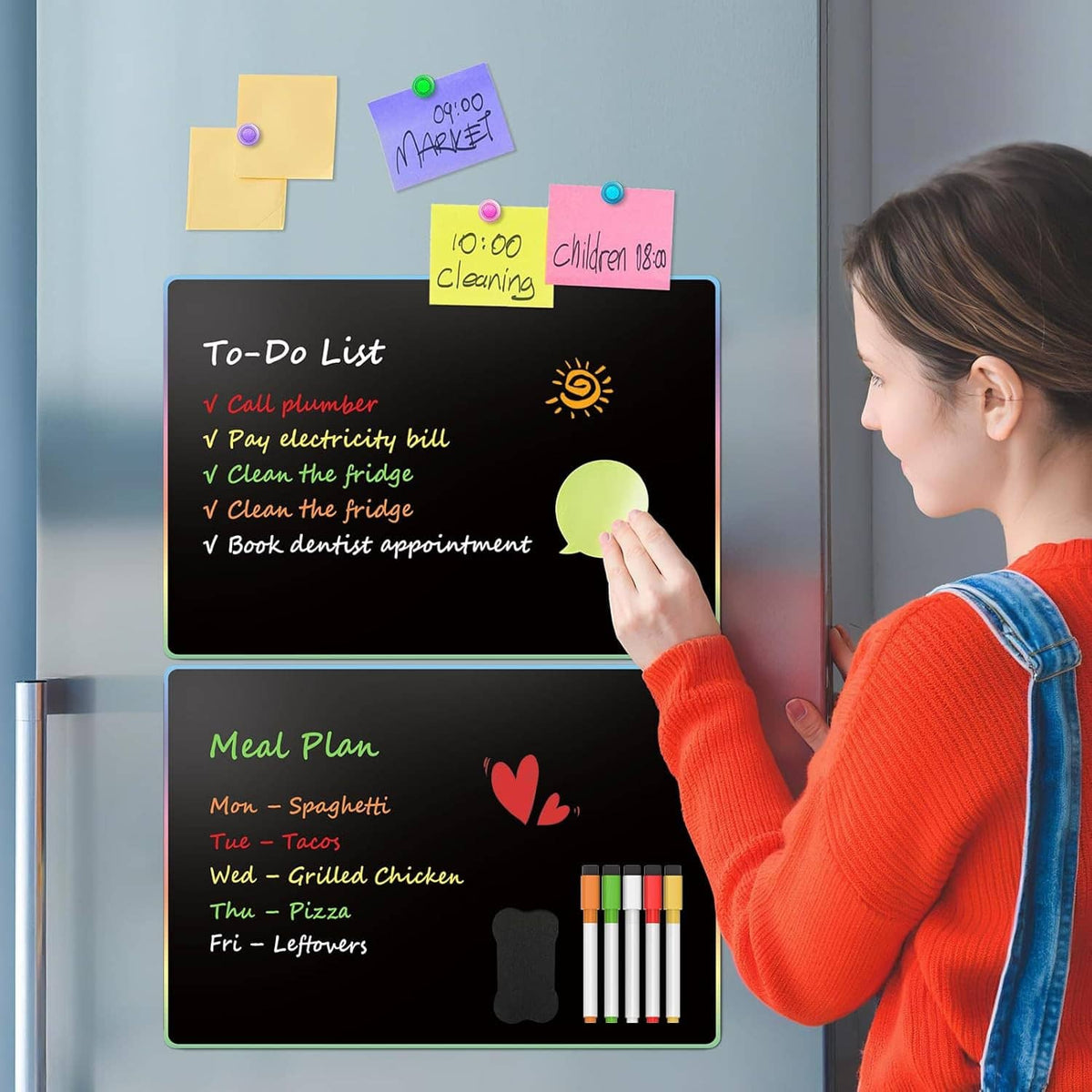 Person writing on two magnetic dry erase boards on a refrigerator