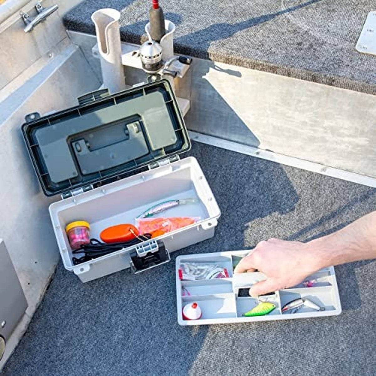 Open grey tackle box showing inner compartments with small fishing/craft items stored