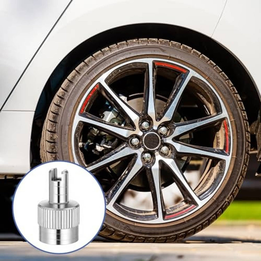 Silver slotted tire valve stem cap with valve core shown beside a car wheel