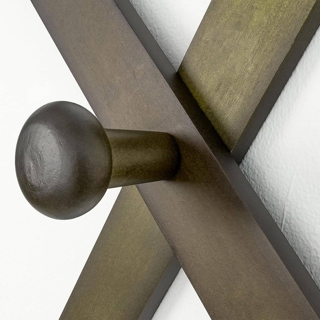 Close-up of dark round hook on a wooden accordion wall hat rack