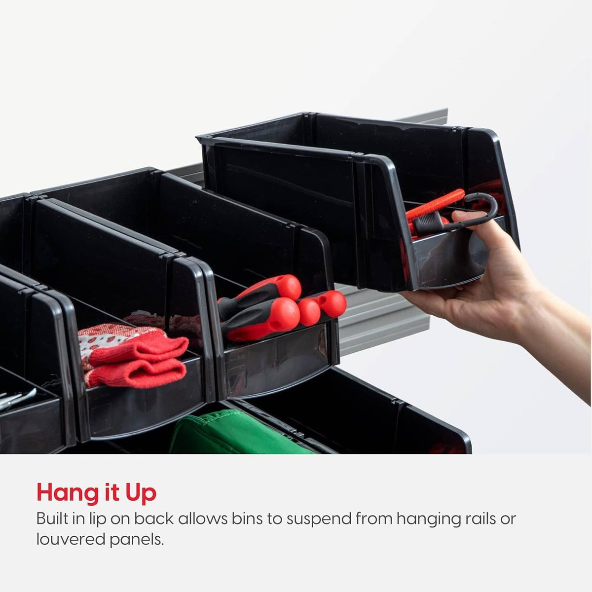 Black stackable storage bins with open front compartments and a hand placing bin