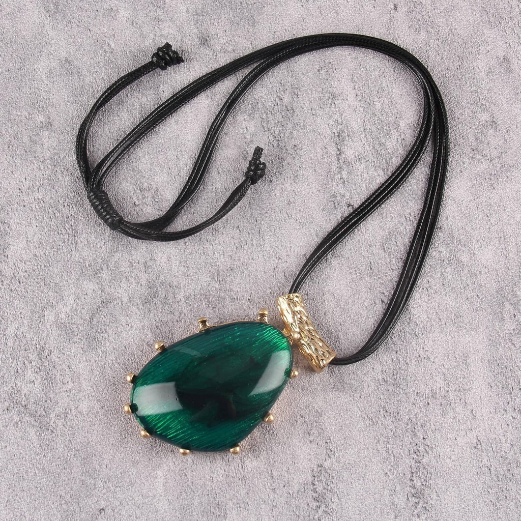 Green teardrop pendant necklace with black faux leather cord, gold frame, and knot ends