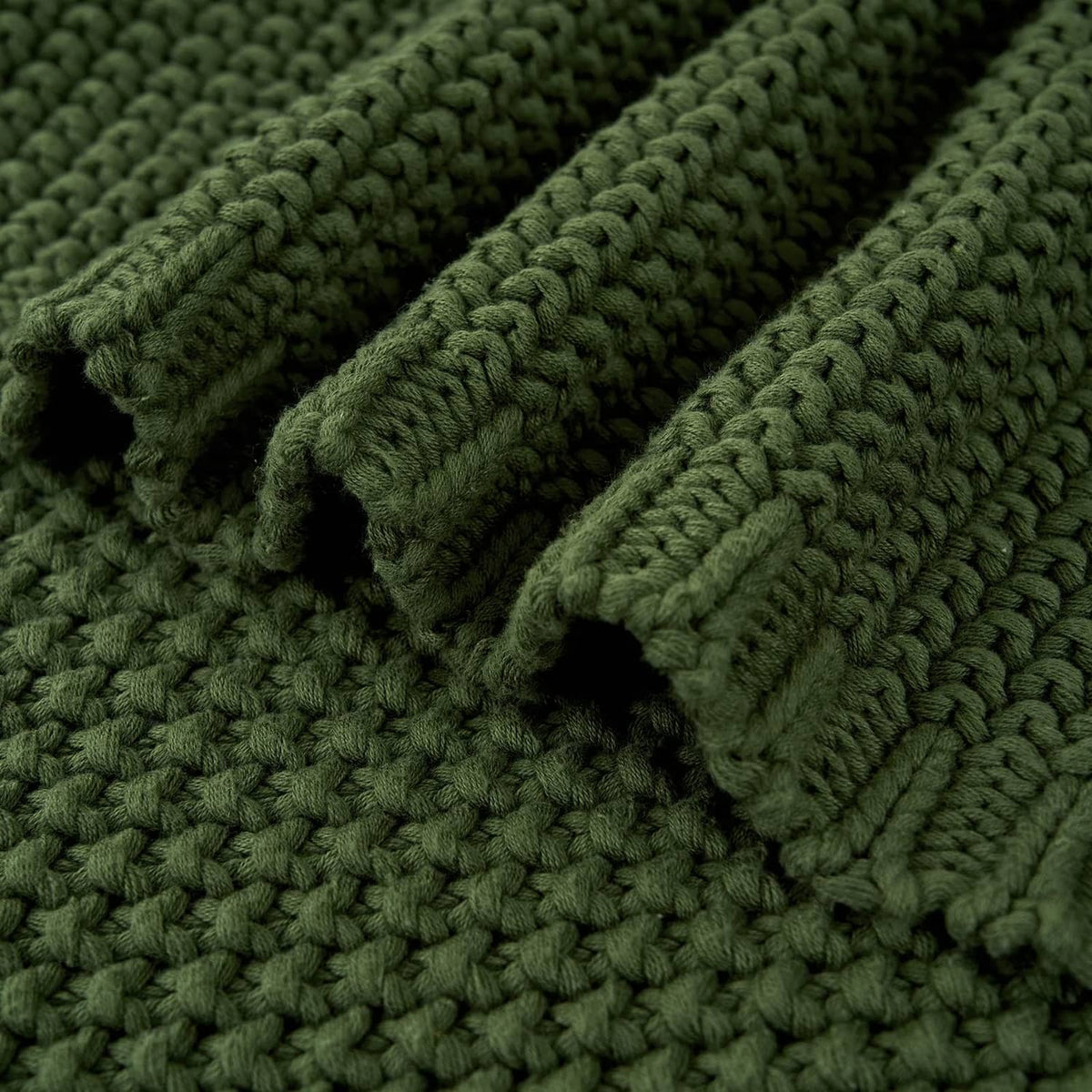 Olive green chunky cable knit blanket texture close-up