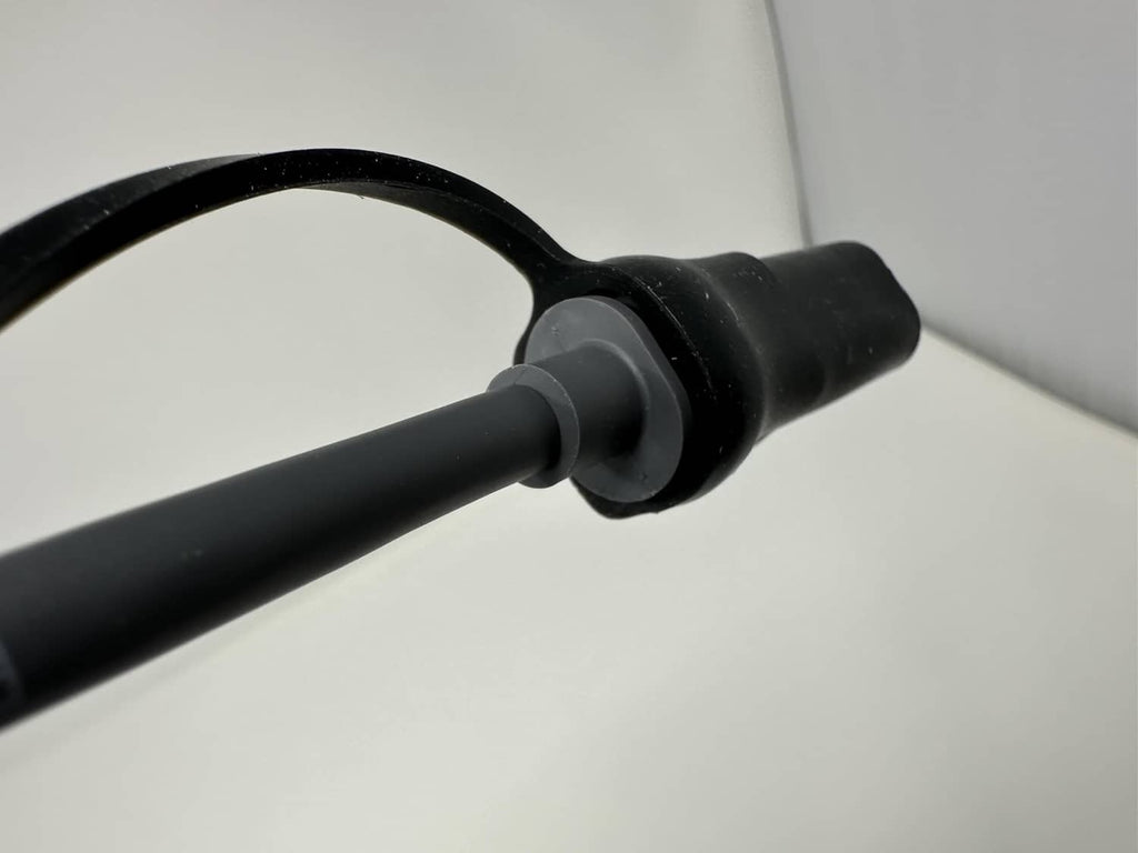 Black silicone end cap with lanyard loop sleeve, close-up on cable tip