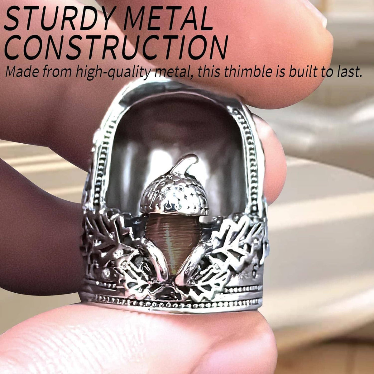Silver metal nail thimble detail with acorn top and ornate leaf pattern