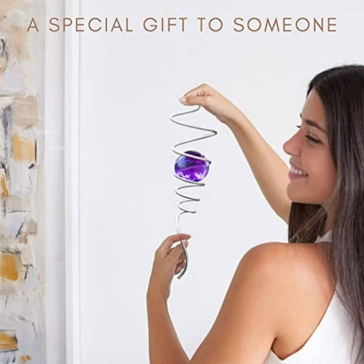 Silver spiral tail wind spinner with purple gazing ball, held near doorway