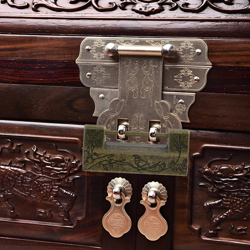 Antique bronze lock plate on a wooden chest with decorative metal latch