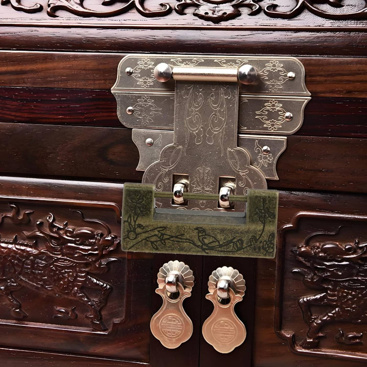Antique bronze lock plate on a wooden chest with decorative metal latch