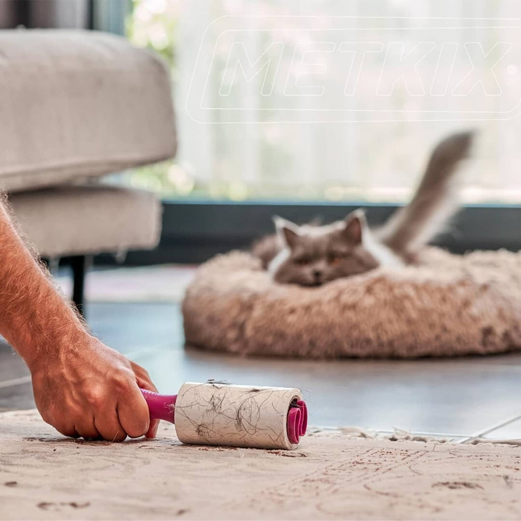 Pink Metkix lint roller refill removing pet hair from carpet and sofa area