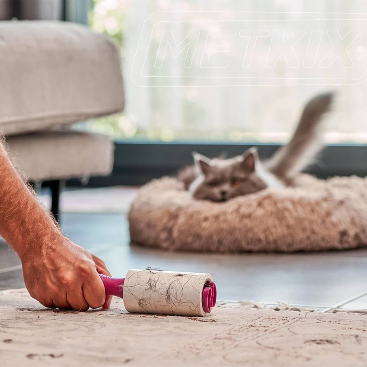 Pink Metkix lint roller refill removing pet hair from carpet and sofa area