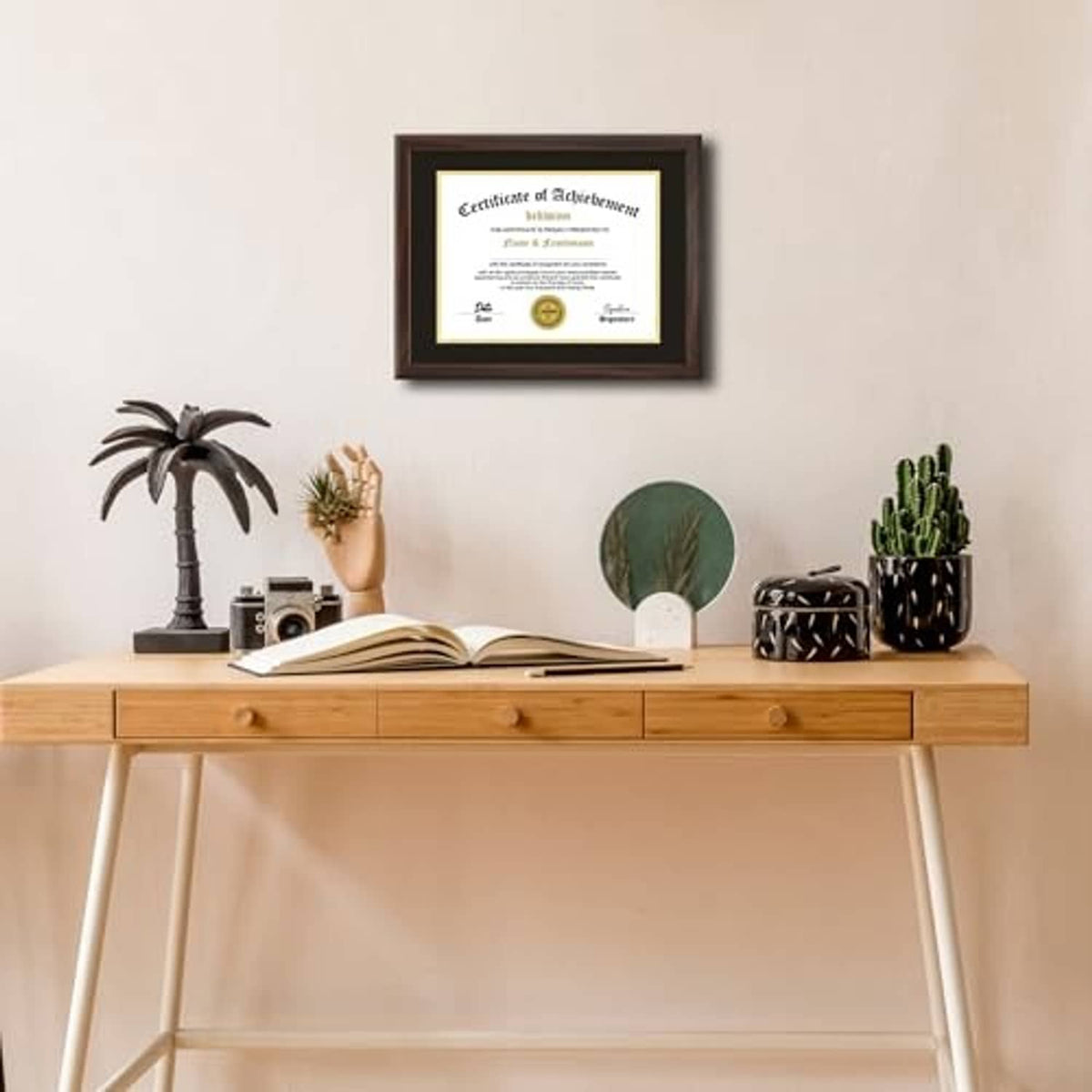 Walnut framed certificate with black mat and gold border displayed on a wall