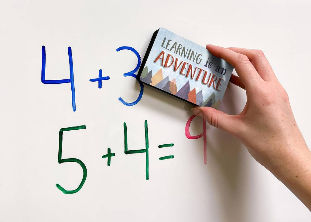 Magnetic whiteboard panel with “Learning is an Adventure,” shown with hand placing pieces