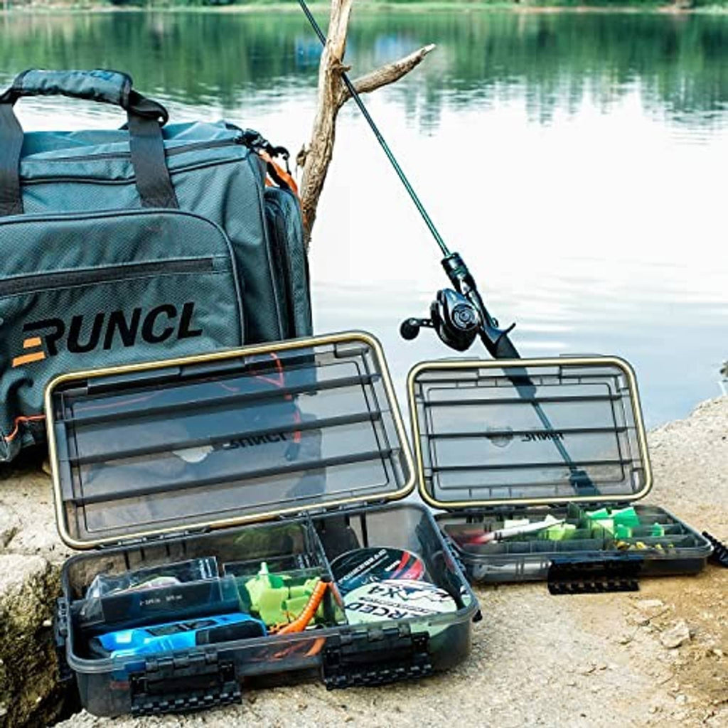Fishing tackle box system open on lakeshore with bait and lure storage trays