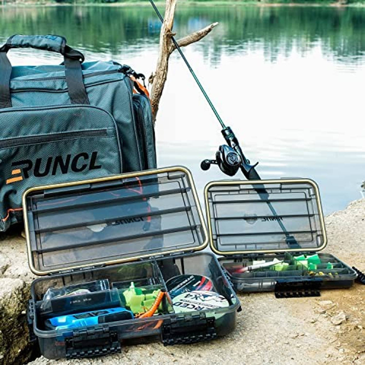 Fishing tackle box system open on lakeshore with bait and lure storage trays