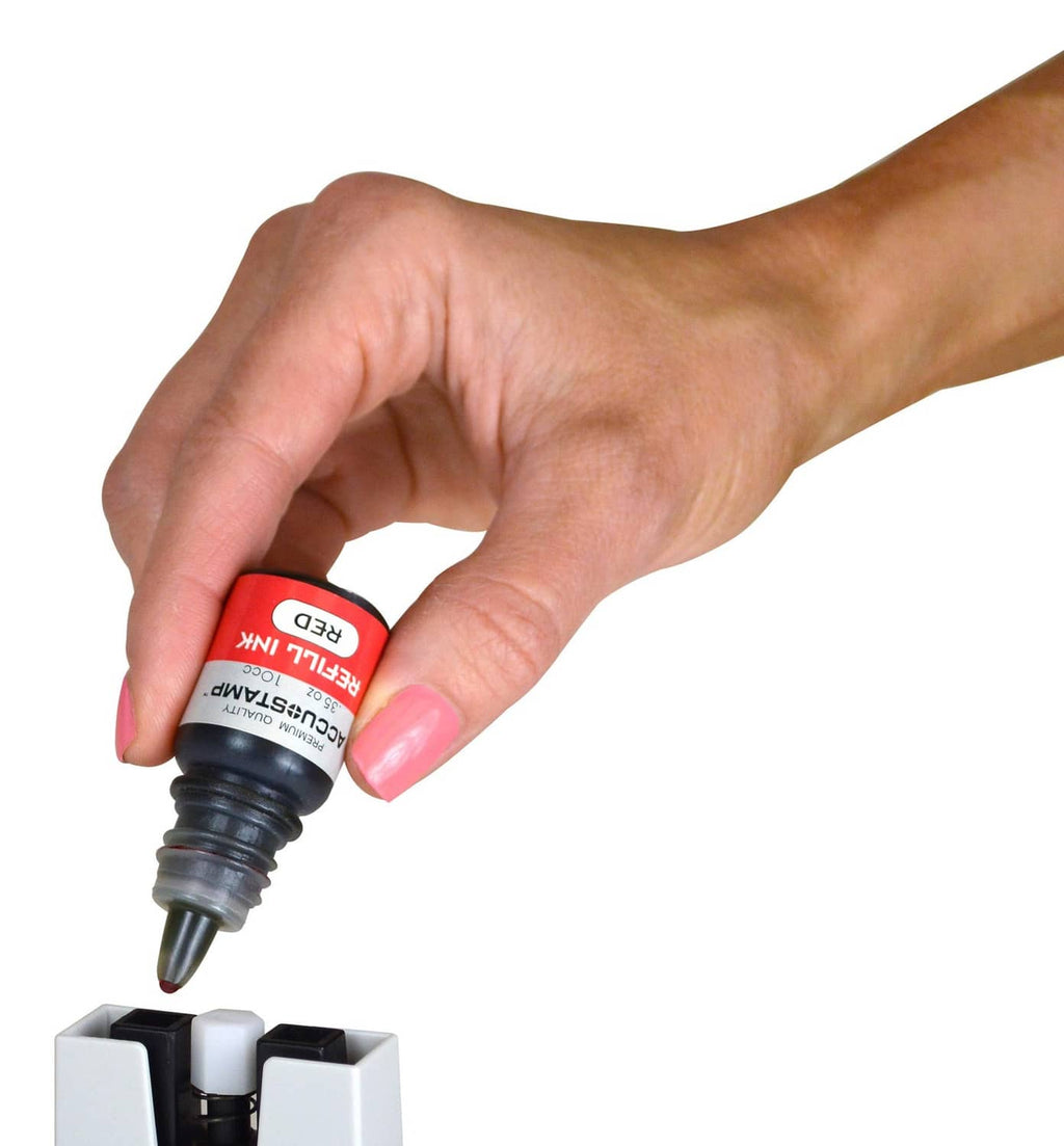 Hand holding blue Accu-stamp ink refill bottle above dispenser