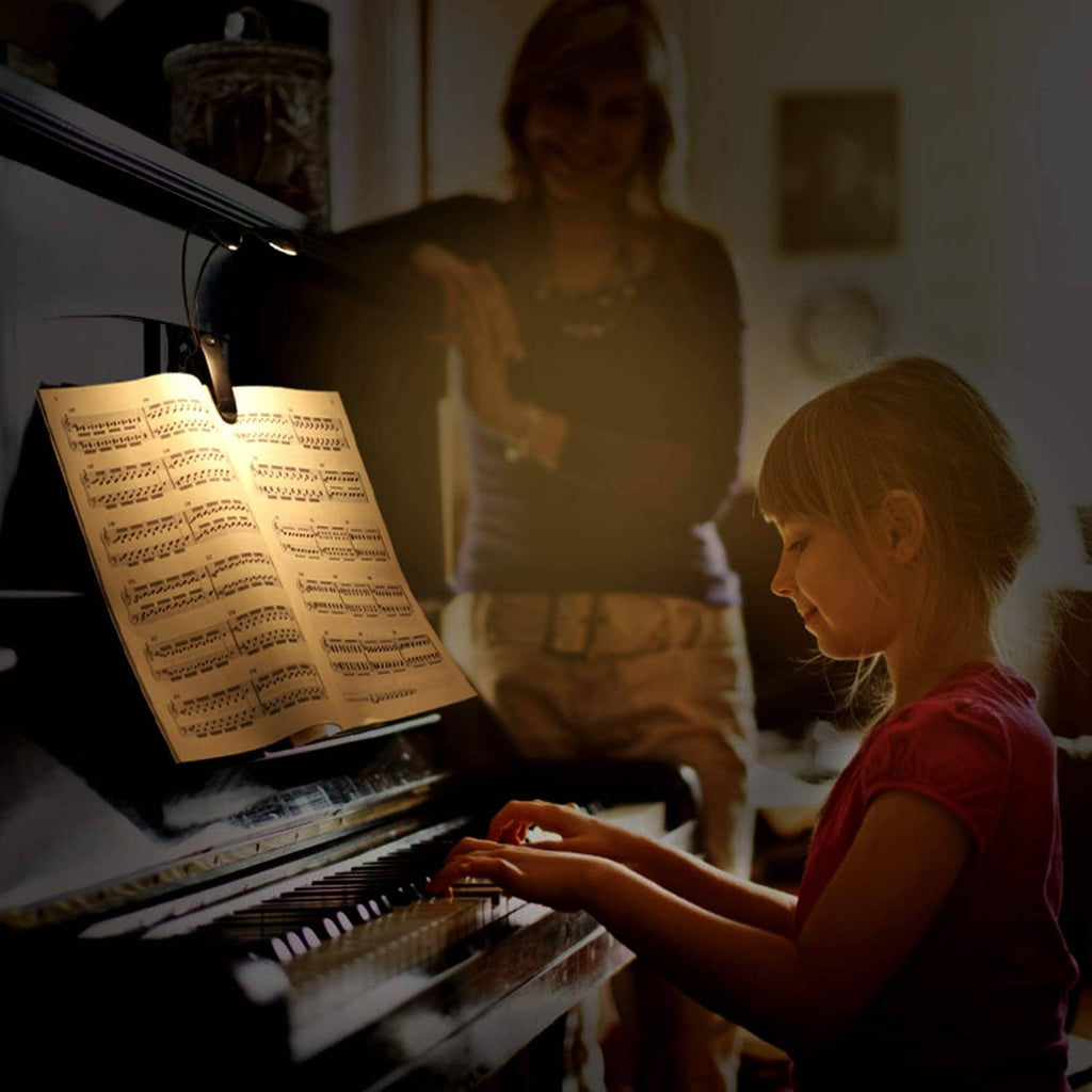 Clip-on music stand light illuminating open sheet music on a stand