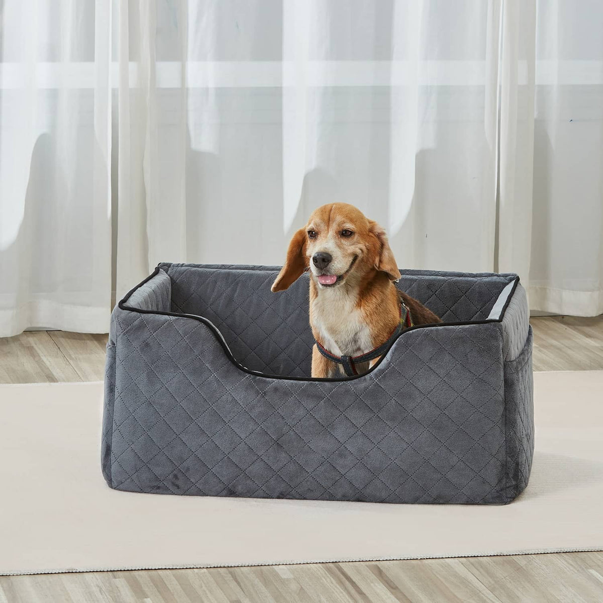 Gray quilted pet booster seat with dog sitting inside on floor