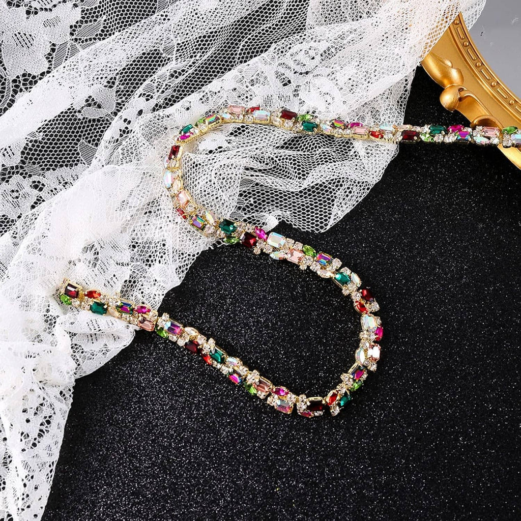 Multicolor rhinestone trim chain looped on black fabric with white lace behind