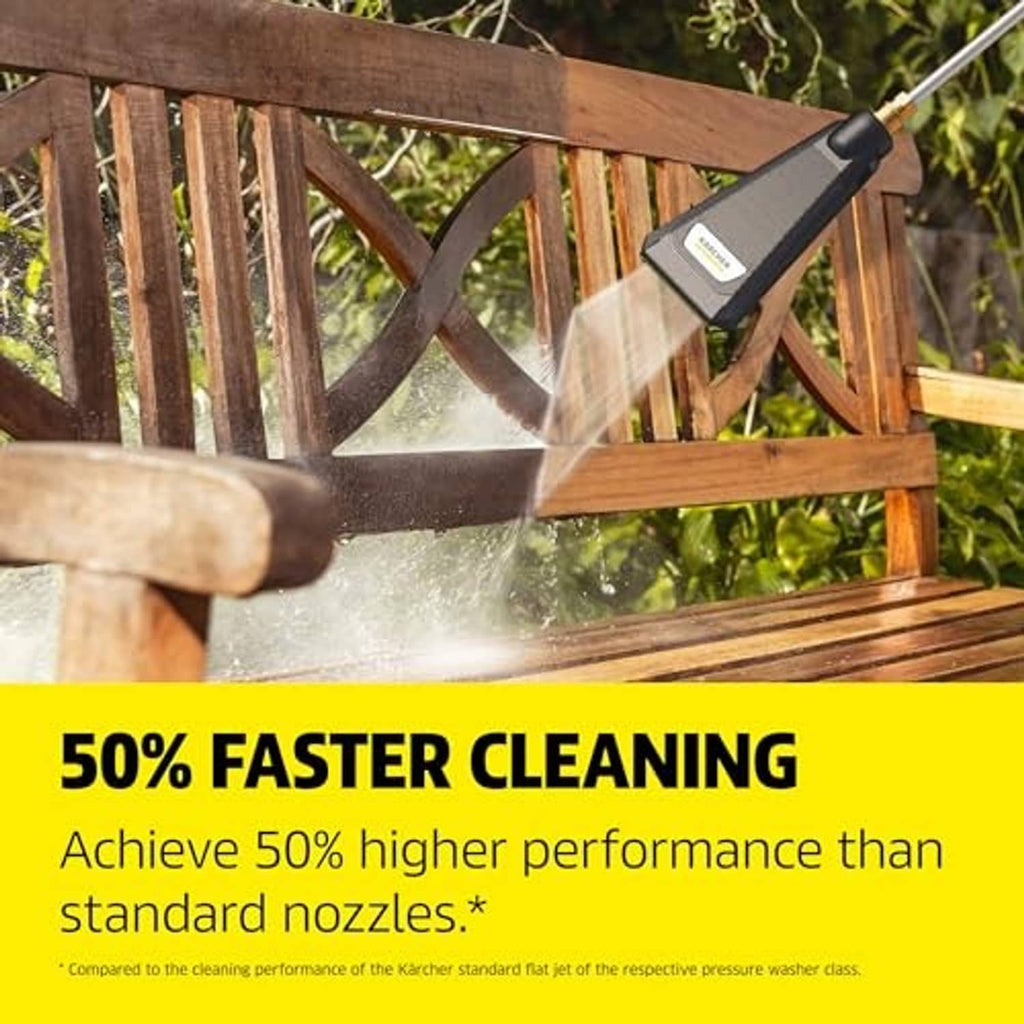 Pressure washer nozzle spraying a fan of water toward a wooden fence, held outdoors