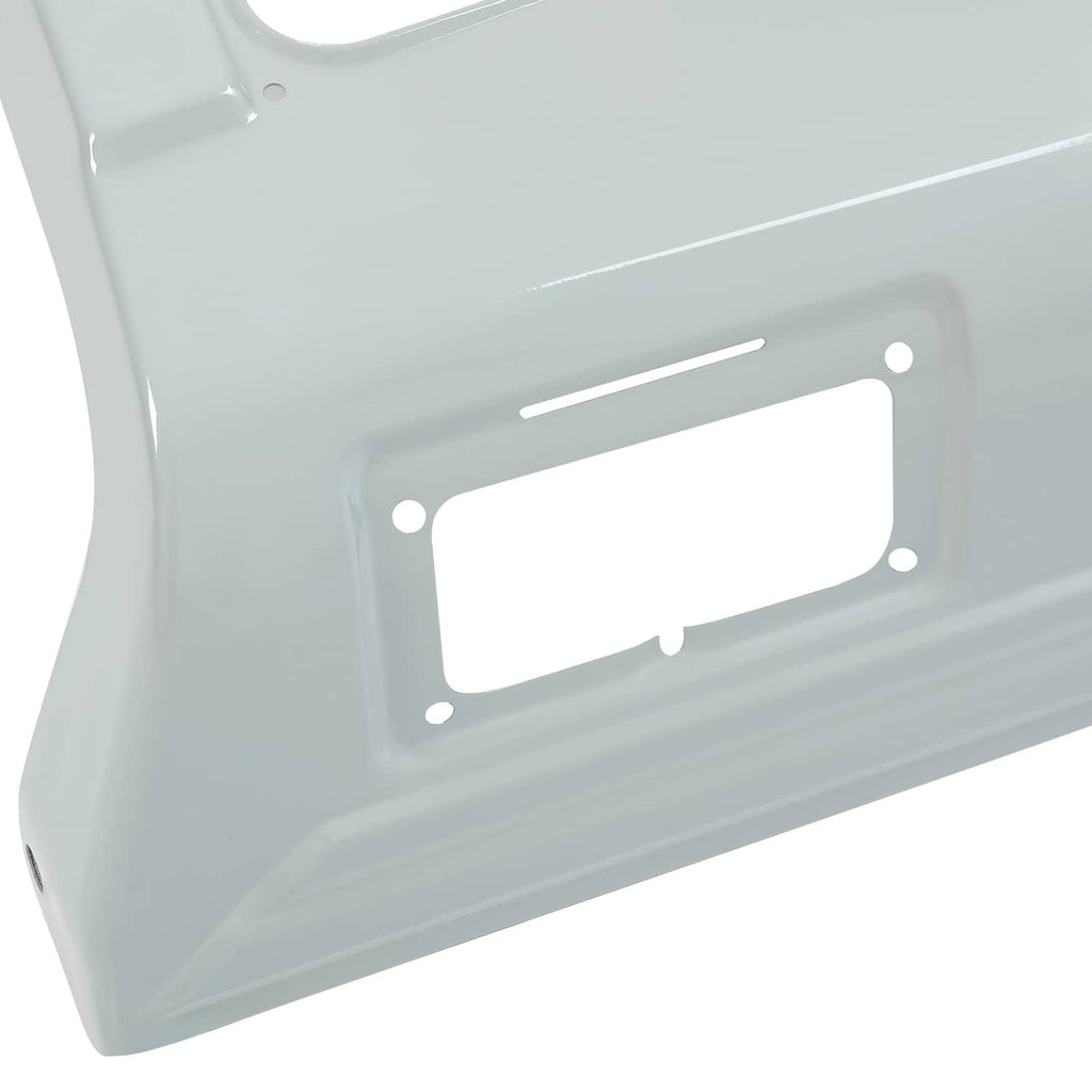 Close-up of gray tractor hood panel with rectangular battery-door cutout