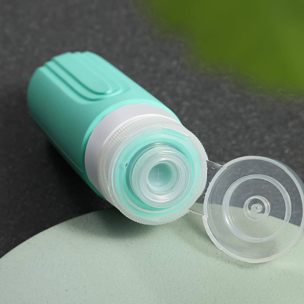 Mint green travel bottle with open nozzle cap, white inner valve visible