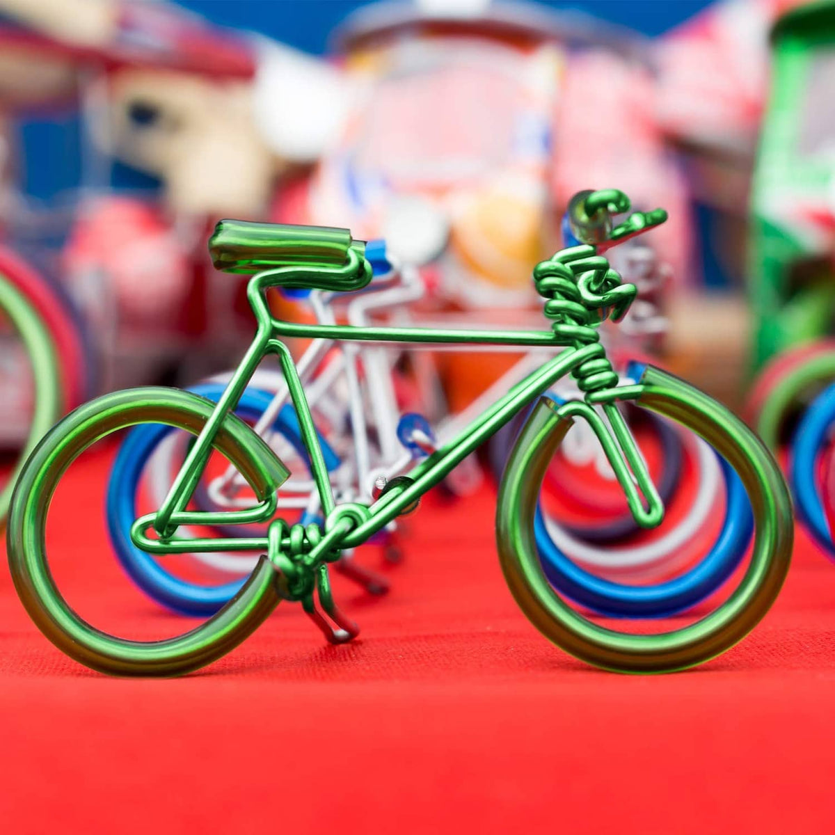 Green aluminum wire bicycle sculpture with coiled wheels and frame details