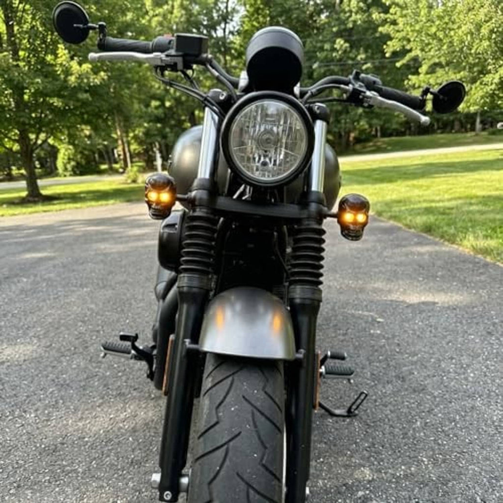 Front amber LED turn signals on black motorcycle with skull-style black housings