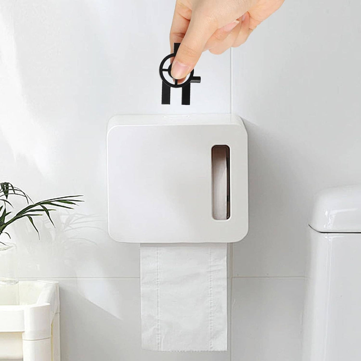 Toilet paper dispenser keys with keyring, black and metal, beside white dispenser