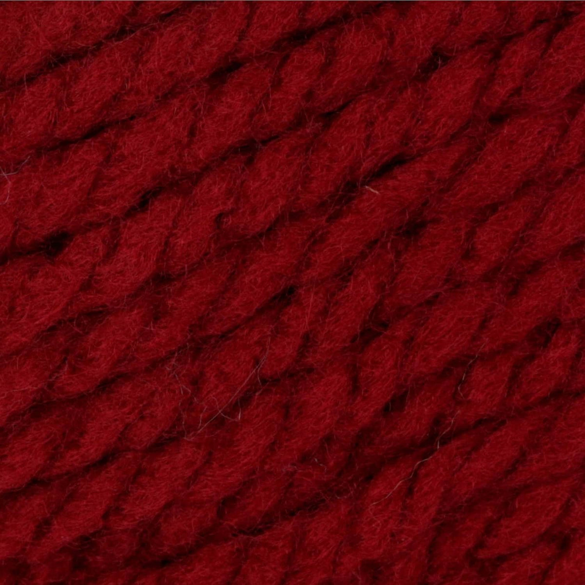 Close-up of dark red chunky acrylic yarn texture with thick twisted strands