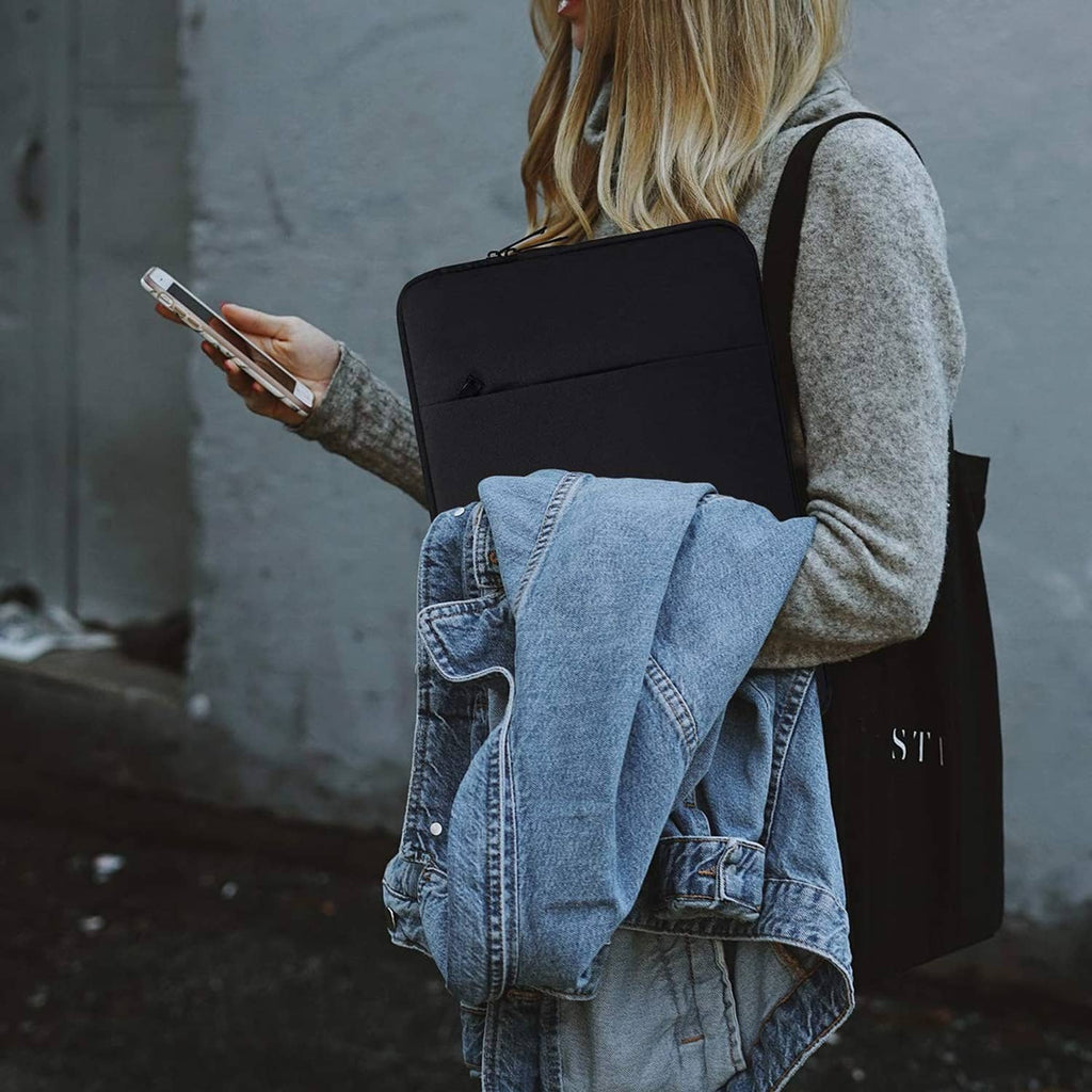 Black tablet sleeve with shoulder strap, worn while holding a drawing stylus