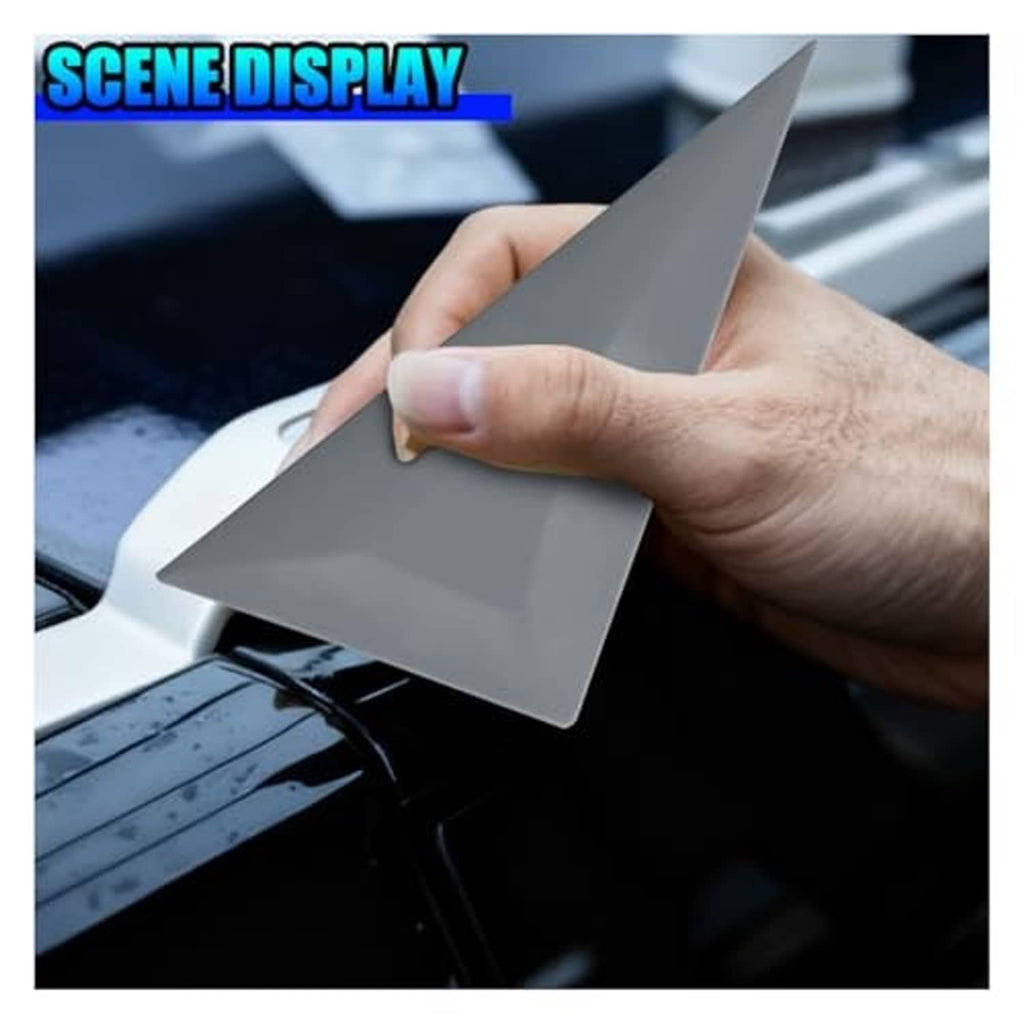 Gray triangular squeegee held by hand for trimming window tint