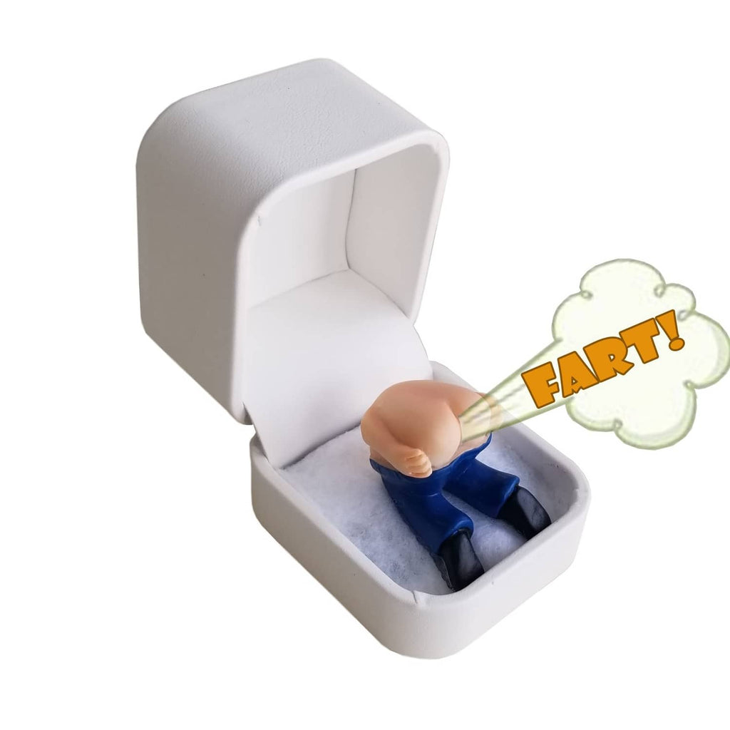 White ring gift box open; blue prank ring in gray insert with fart icon