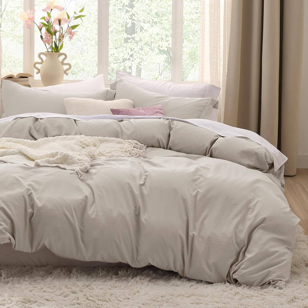 Queen duvet cover set with pillow shams in soft light beige on a bed