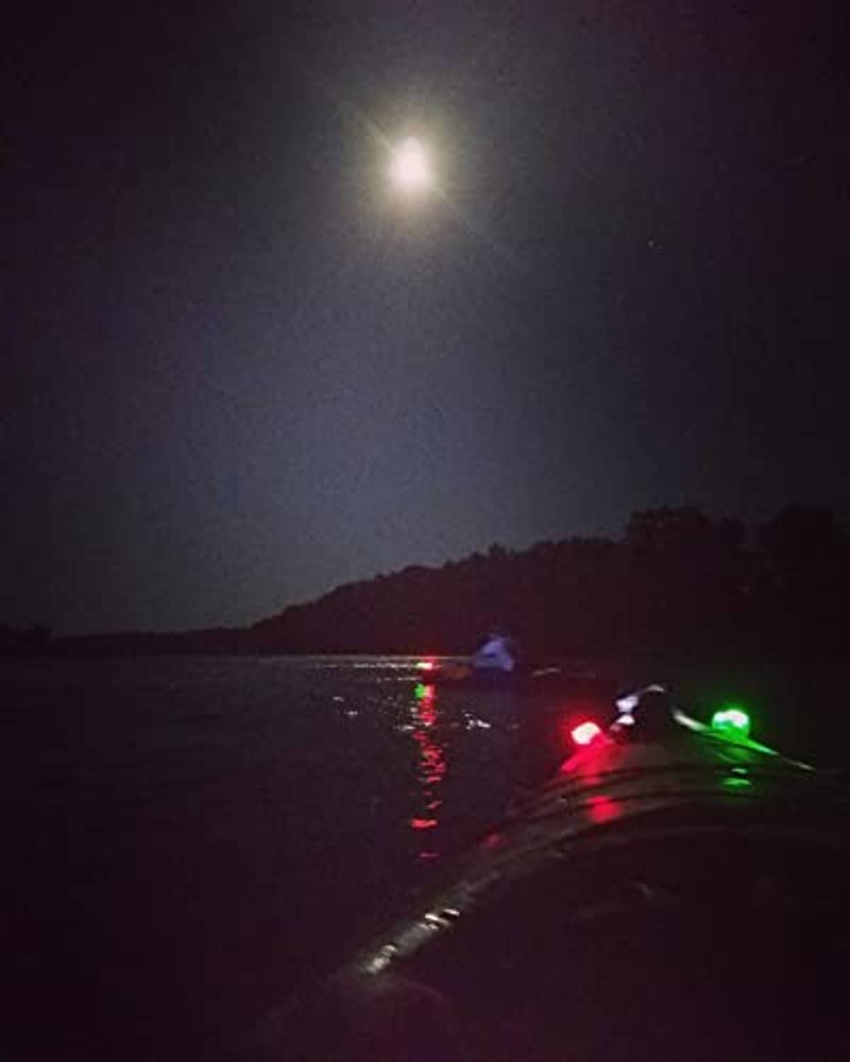 Green and red LED navigation lights on small boat at night, glowing along the bow