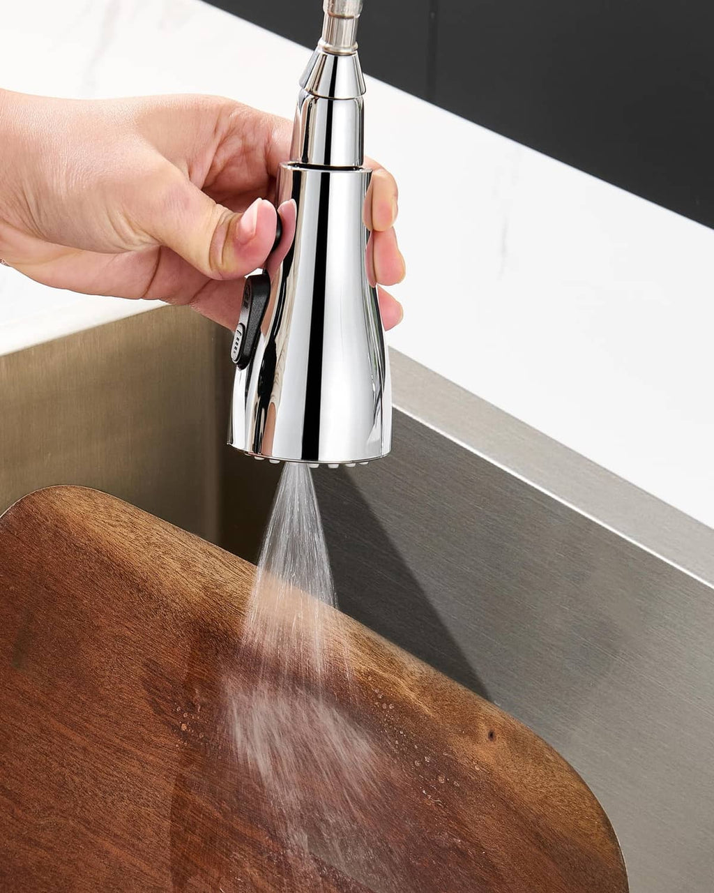 Chrome faucet sprayer head blasting water stream into sink