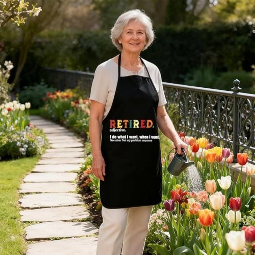 Black sleeveless apron with 'RETIRED' slogan worn by woman in a garden