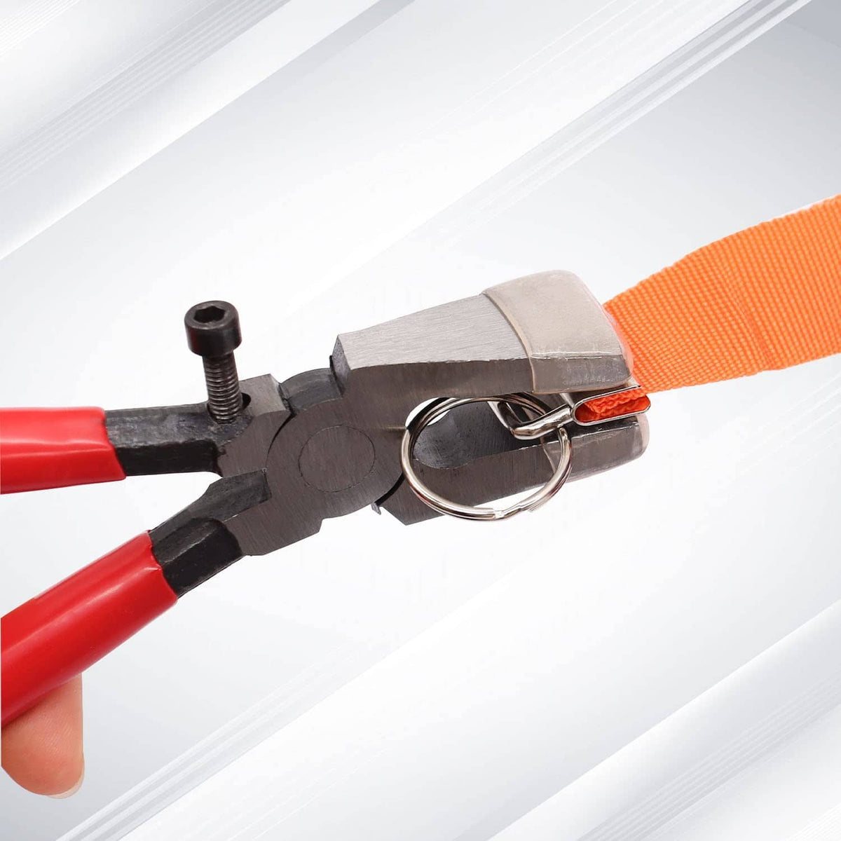 Key fob clamp hardware with silver jaws gripping orange strap and ring