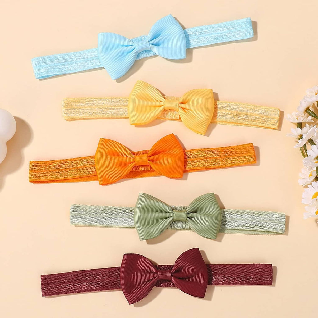 Assorted baby headbands with large fabric bows, laid out flat